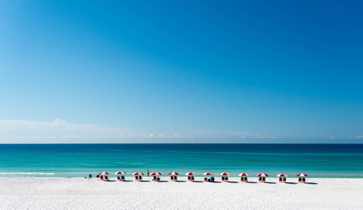 Row of beach chairs facing calm turquoise water