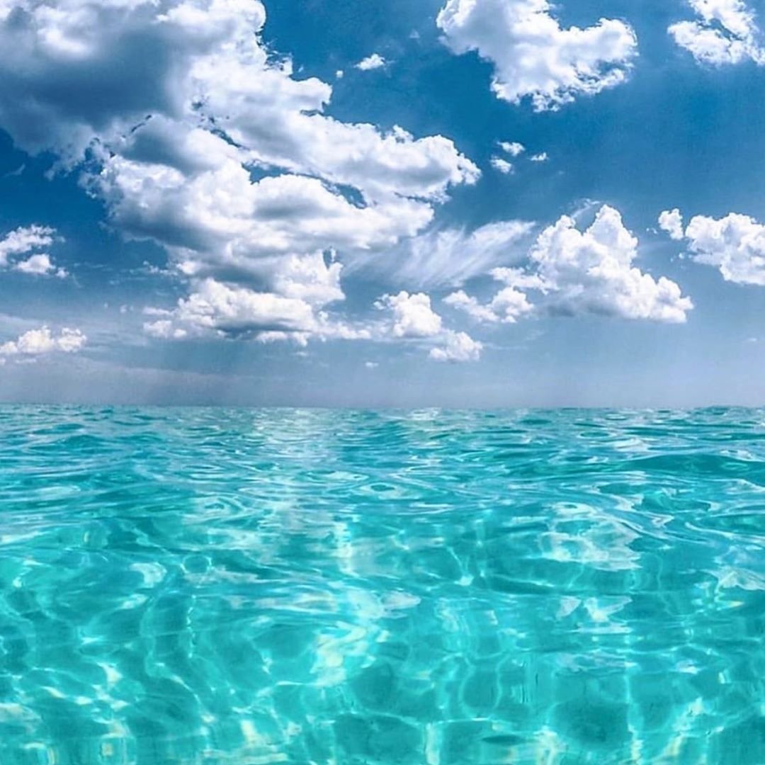 Clear turquoise Gulf water beneath dramatic clouds