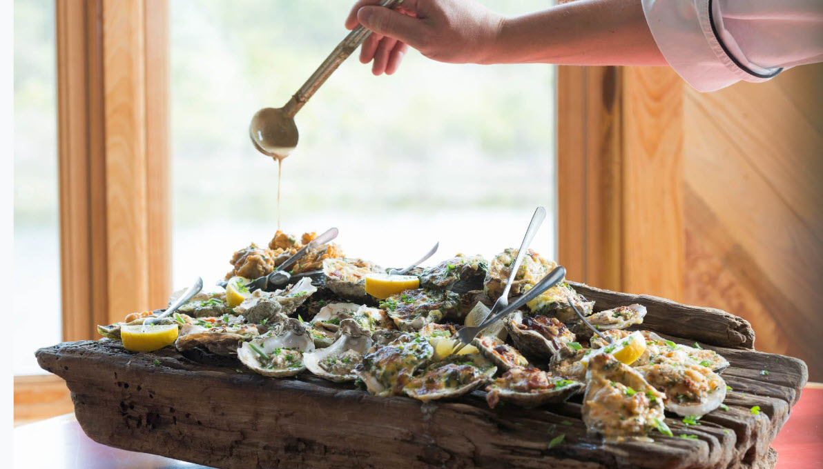Chef garnishing a baked oyster dish