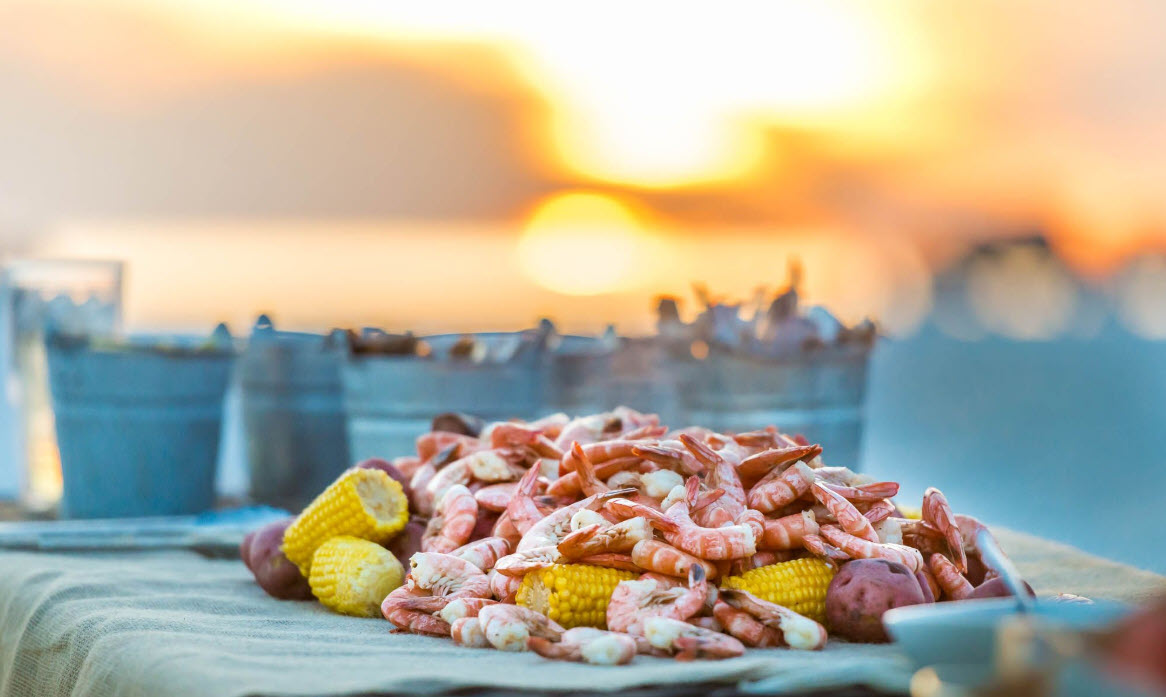 Seafood boil served beside the water at sunset