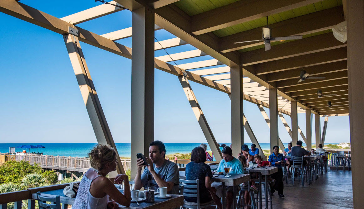Diners seated on a covered beachside patio