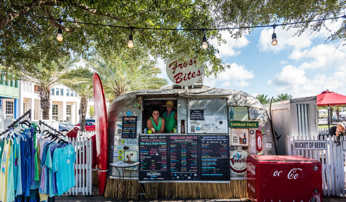 Outdoor food stand and apparel shop beneath live oaks