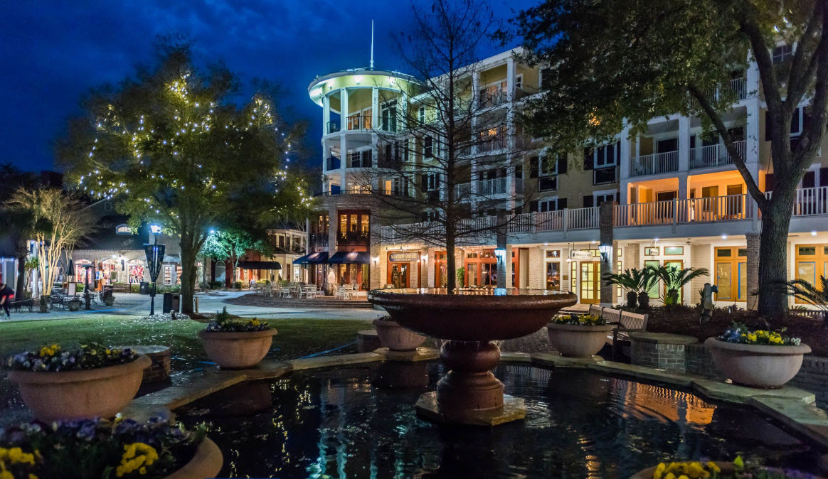 Illuminated pedestrian plaza and fountain at night