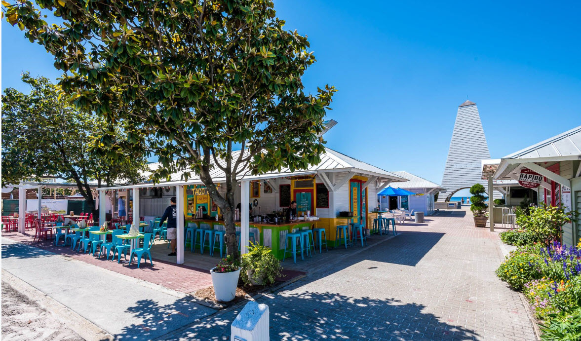 Colorful coastal shops surrounding an outdoor plaza