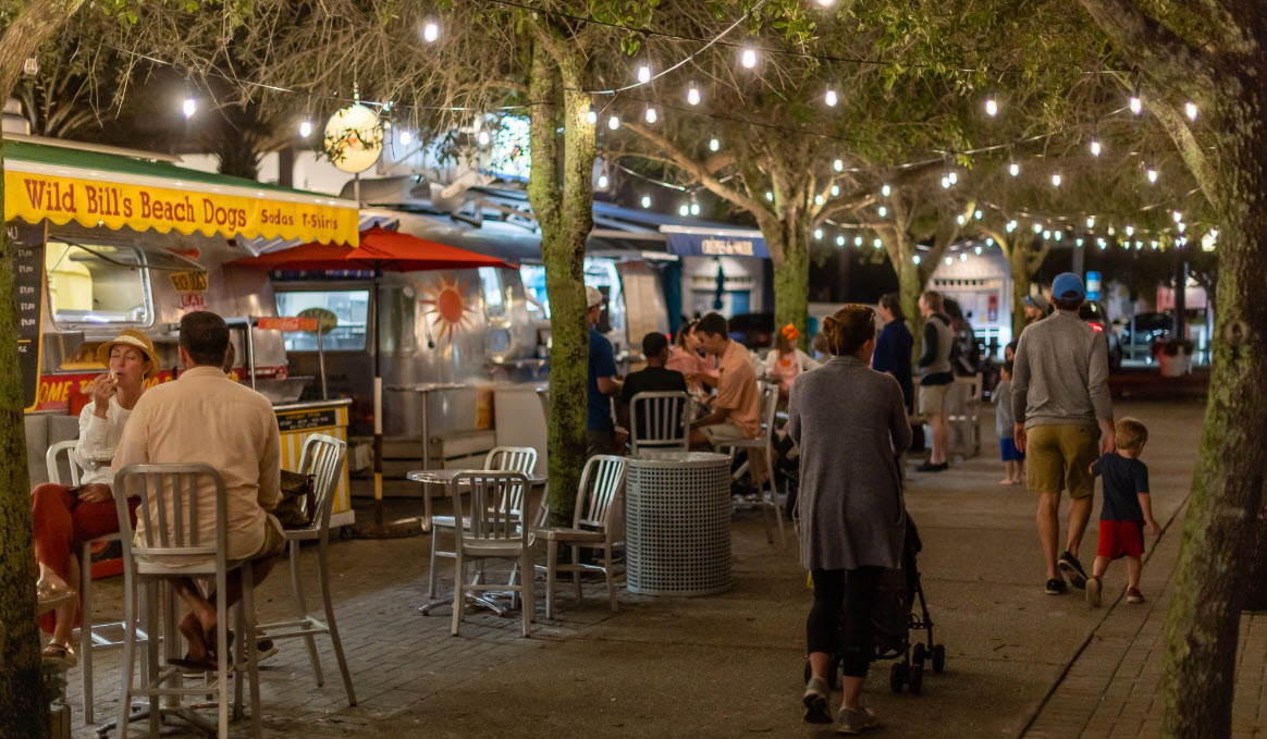 Food truck gathering under string lights