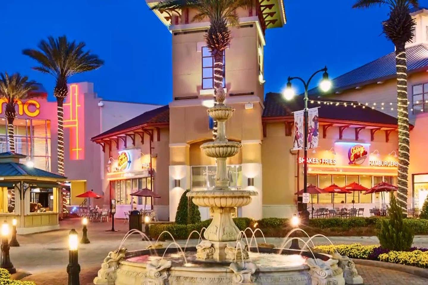 Evening entertainment plaza with a fountain and palm trees