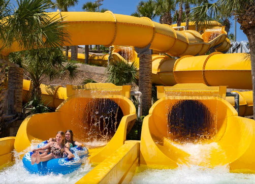 Family riding side-by-side yellow water slides
