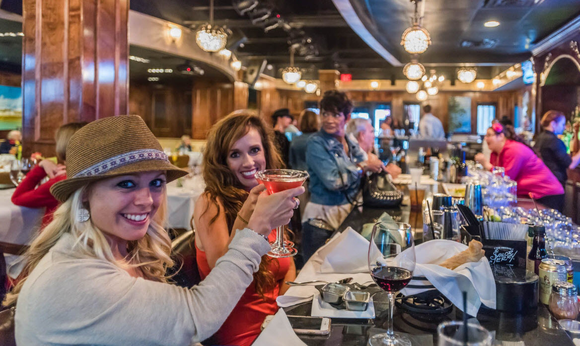 Friends raising glasses inside a lively restaurant