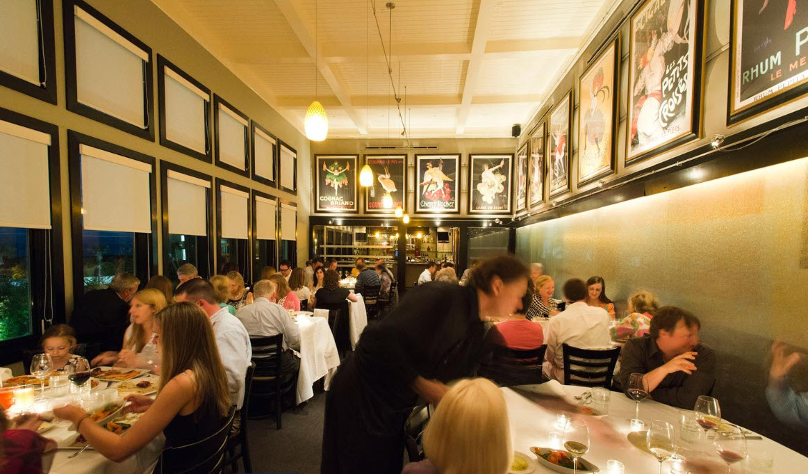 Large group sharing dinner at a long restaurant table