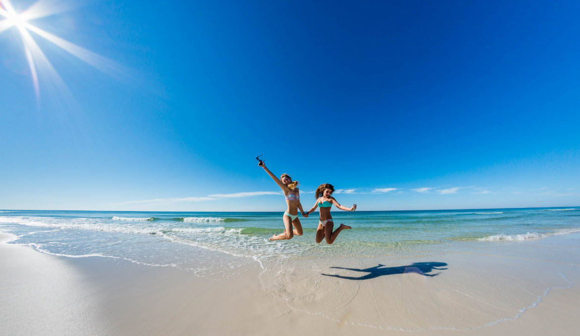 Two children playing on a wide sunlit beach