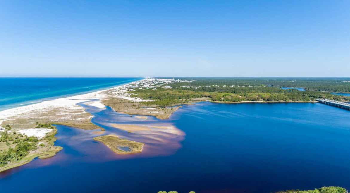 Aerial view of an inlet between white beach and blue bay