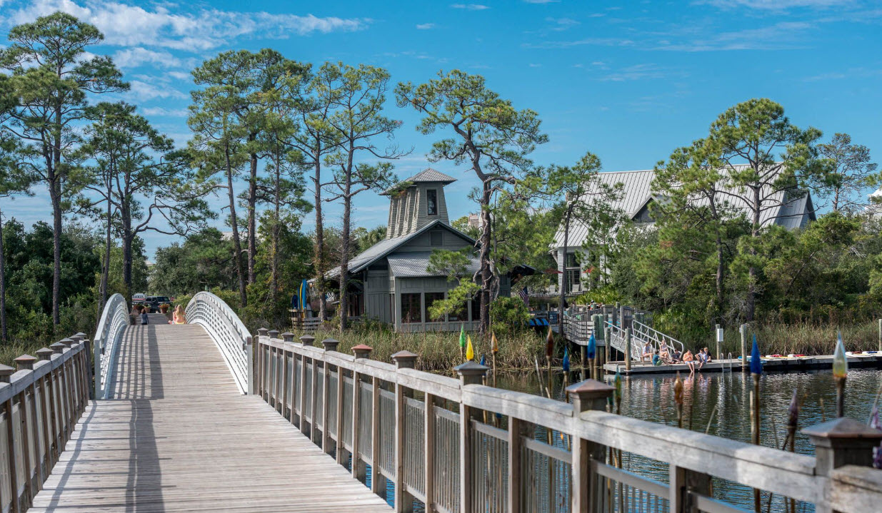 Wooden boardwalk crossing wetlands toward a small chapel