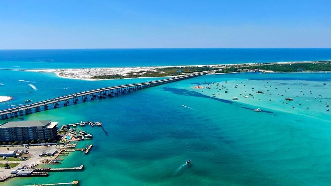 Aerial view of jetties, marina, and turquoise coastline