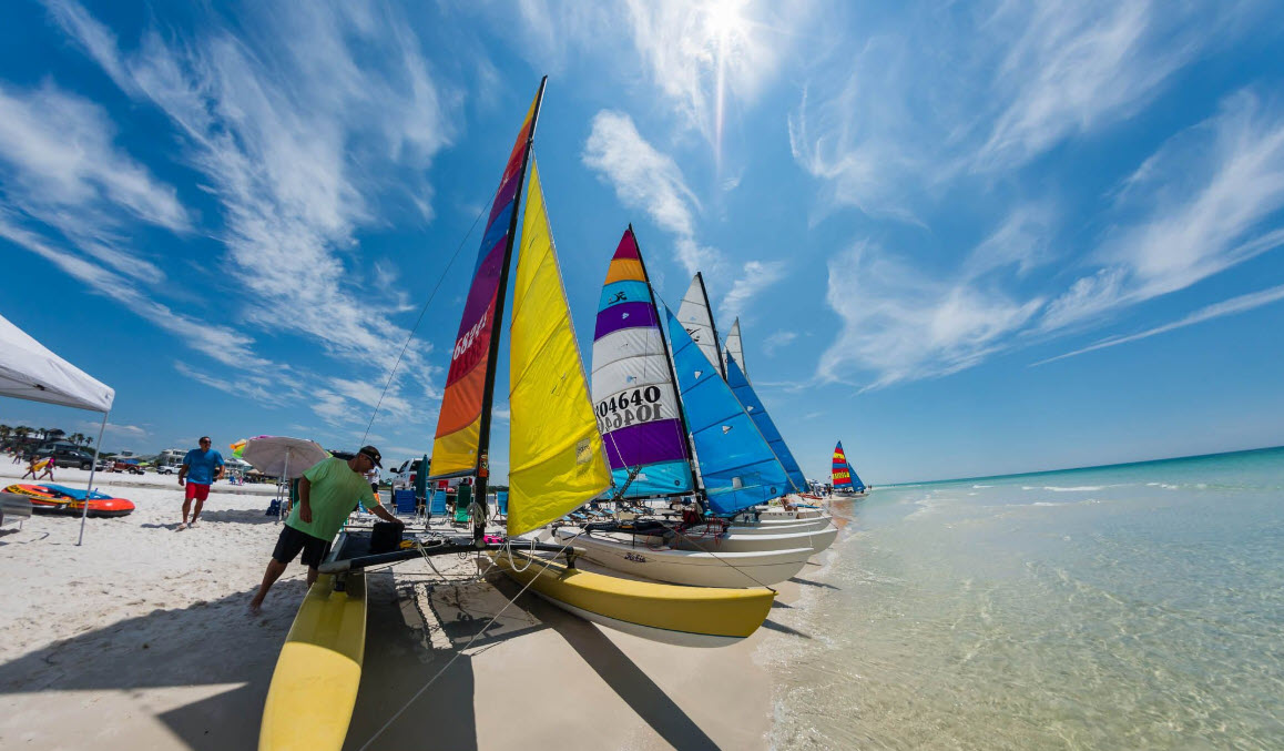 Colorful sailboats lined up in shallow Gulf water