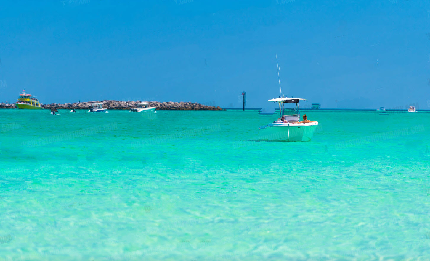 Small boat floating on vivid emerald water