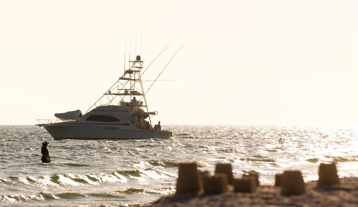 Sportfishing boat cruising offshore in bright sunlight